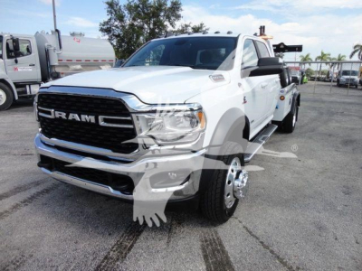 Ram 5500 SLT heavy-duty truck front-left view showing large black grille with RAM lettering, chrome bumper, dual headlights, white body, single front wheel, winch category listing.