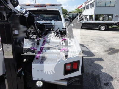 Ram 5500 service bed with winch mounting and control handles, aluminum diamond plate, rear lights visible.