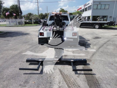 Ram 5500 tow truck rear view showing winch and mounting brackets in lot.