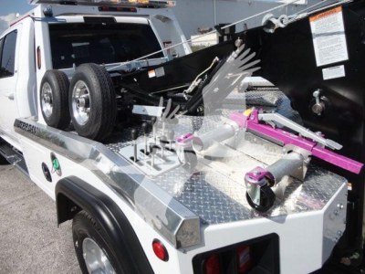 Ram 5500 winch truck bed showing equipment mounts and wheels with purple & pink hydraulic components.