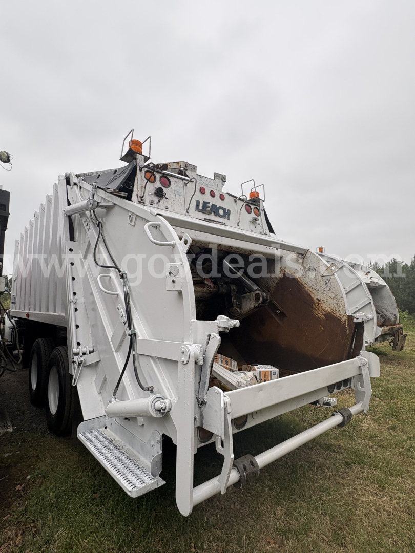 Sterling LT8500 rear view showing dump bed and hydraulic mechanism, white exterior, trailer wheels, and tailgate components.