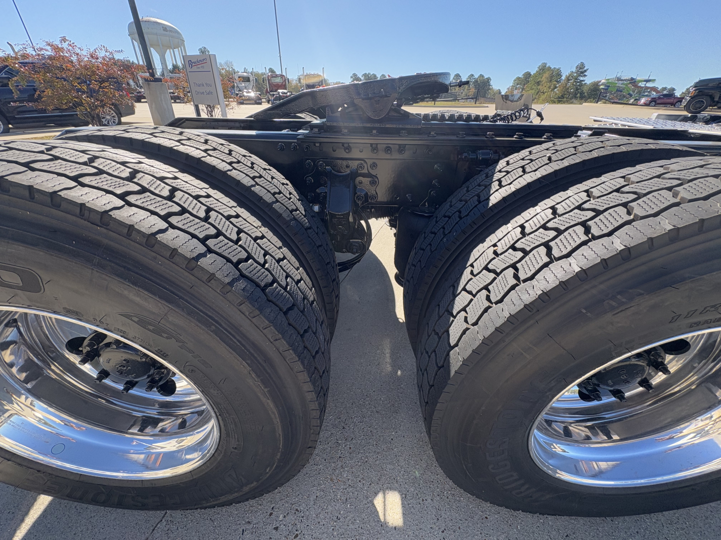 Mack PR64T truck chassis showing dual rear axles with large tires and chrome wheels, front view from between the wheels.
