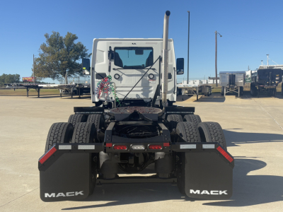 Truck rear view of a new 2026 Mack PR64T with dual rear axles and mud flaps labeled MACK in a truck yard.