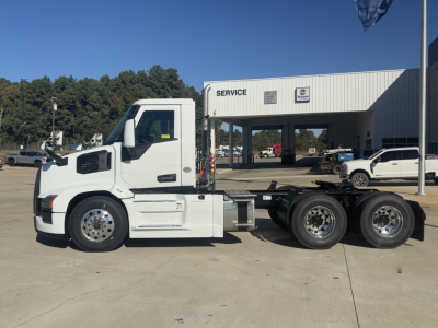 Tractor unit shown in side profile, white Mack PR64T with car hauler chassis, parked in front of service building.
