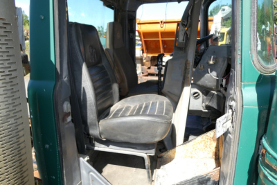 Cab interior of a 1999 Mack RD688S showing driver and passenger seats with dashboard and doorway visible.