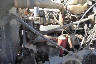 Engine bay showing Mack RD688S chassis components with hoses, lines, and fluid reservoirs.