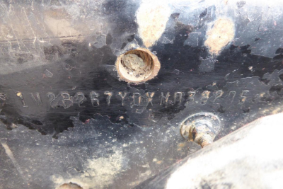 Mack RD688S cab and chassis showing VIN stenciled on a dark surface with bolts and dirt.