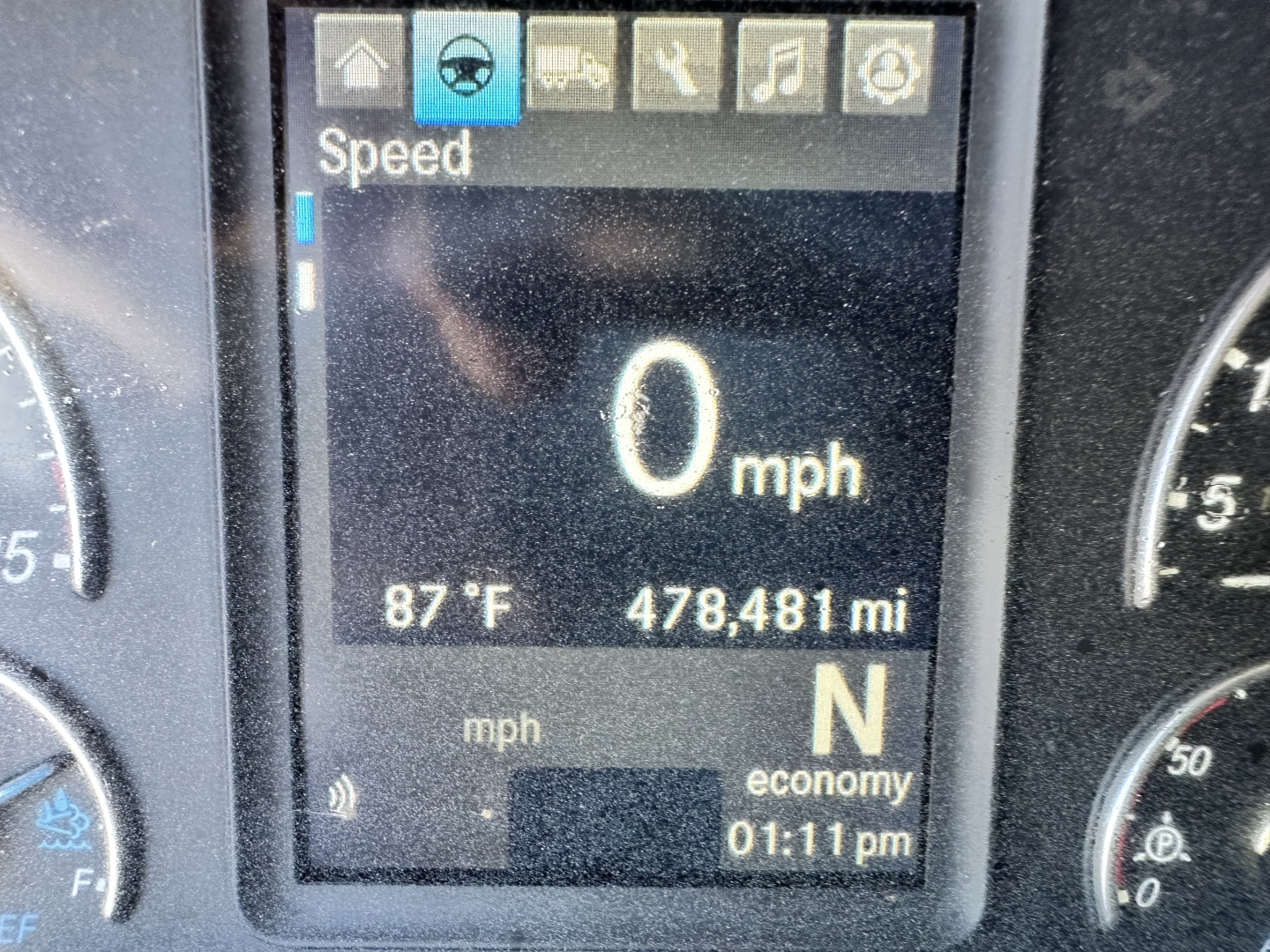 Dashboard display in a Freightliner Cascadia showing speed 0 mph, temperature 87°F, mileage 478,481 mi, gear N, time 1:11 pm.