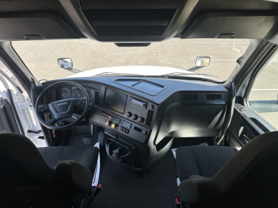 Cab view of a 2023 Freightliner Cascadia 126 truck interior showing steering wheel, dashboard, and driver and passenger seats.