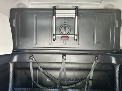 Truck cargo area of a 2023 Freightliner Cascadia 126 showing inside sleeper storage with a mounted accessory and rear wall panels.