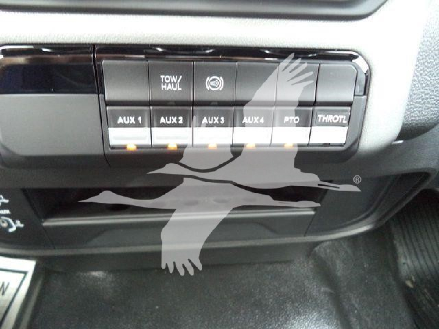 Ram 4500 dash panel showing AUX switches labeled AUX 1 AUX 2 AUX 3 AUX 4, TOW/HAUL, PTO, THROTTLE, with additional small icons.