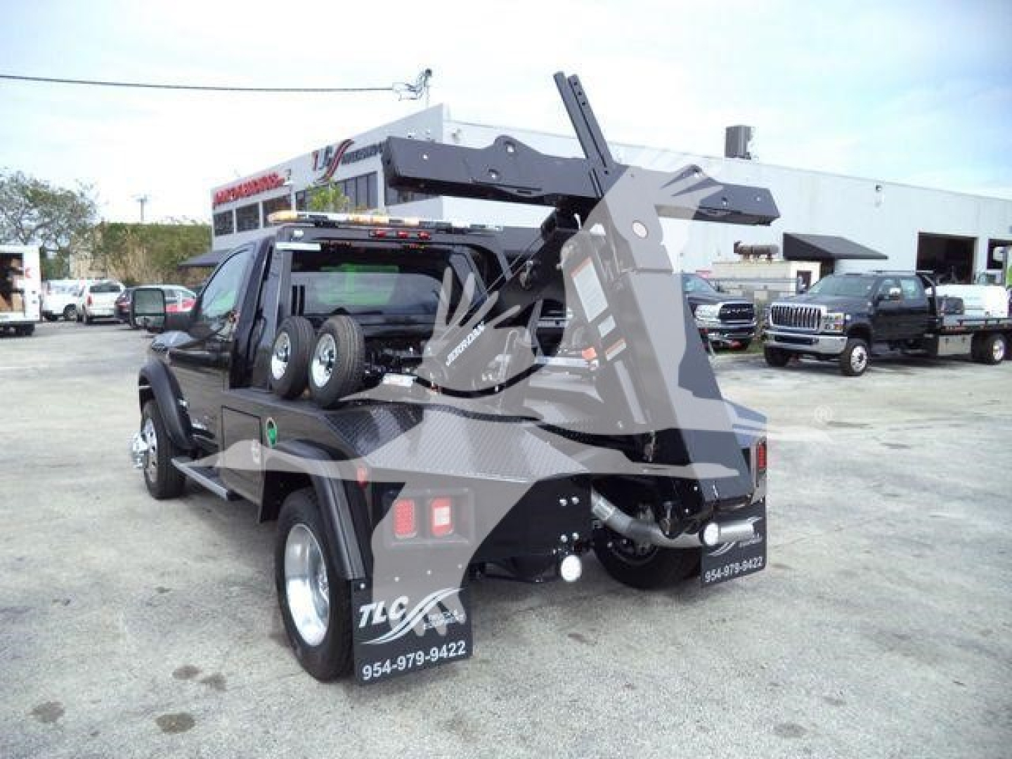 Ram 4500 Tow Truck with hydraulic lifting arm and winch system mounted on a flatbed, side view showing rear and ramp equipment.