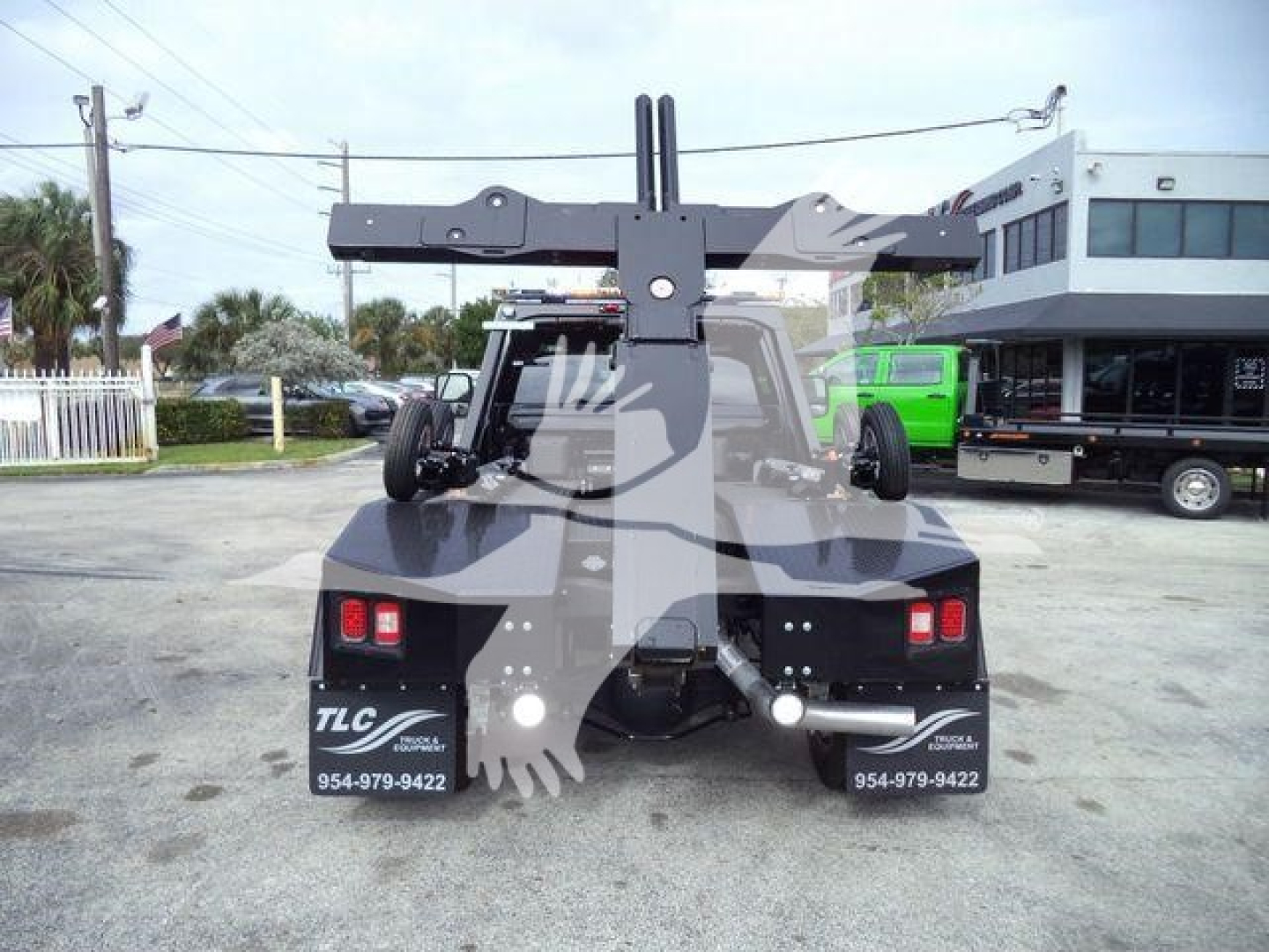 Truck rear view showing winch frame and mounted equipment with TLC decals and contact numbers.