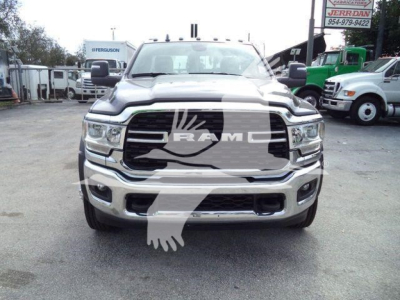 Ram 4500 front grille and bumper with RAM badge and chrome accents, daylight, dealership lot in background.