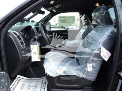 Ram 4500 truck interior with driver and front passenger seats wrapped in plastic, dashboard and steering wheel visible, paper tags hanging from seat.