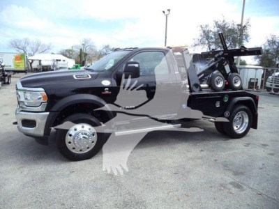 Ram 4500 pickup truck with black tow winch bed showing a blue-tinish winch and spare tire on the bed