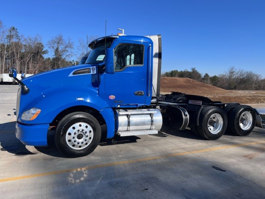 Kenworth T680 daycab tractor in blue side profile showing cab, fuel tanks, and rear axles.