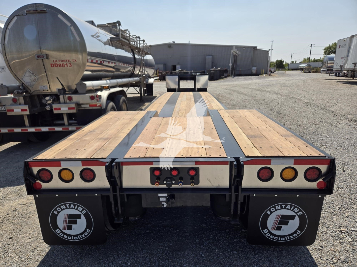 Fontaine renegade X20 trailer rear view showing wooden deck, black steel frame, dual rear under-ride? taillights and mud flaps with Fontaine logo.