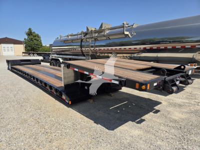 Fontaine Renegade X20 trailer with a long flatbed and a tanker-style cylindrical tank on a dual-axle trailer. Visible are wooden deck planks, metal guard rails, and a load of piping equipment. Serial/stock labels not legible.