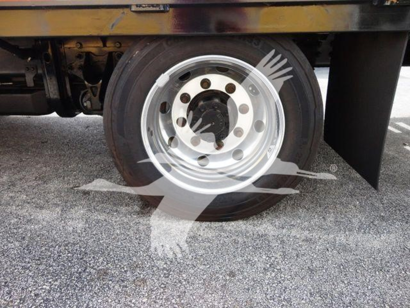 Flatbed truck wheel and hub area of a 2023 Chevrolet Silverado 6500HD, showing steel rim with lug nuts and tire.