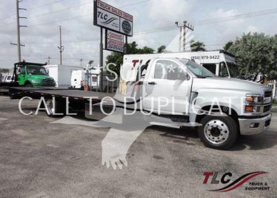 Chevrolet Silverado 6500HD flatbed truck angled view showing crew cab, front chrome bumper, and dual rear wheels with TLC logo watermark.
