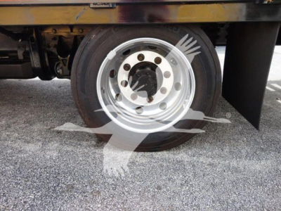 Flatbed truck wheel and hub area of a 2023 Chevrolet Silverado 6500HD, showing steel rim with lug nuts and tire.