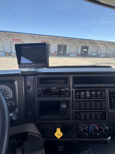 Dashboard view of a 2025 Mack MD7 truck showing the instrument cluster, stereo, and control panels with a mounted navigation screen.