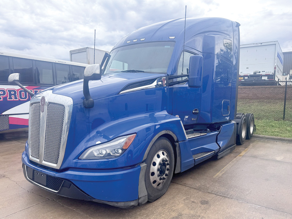 Kenworth T-680 Next Gen tractor-trailer cab in blue, front-left view with aerodynamic mirrors and chrome grille.