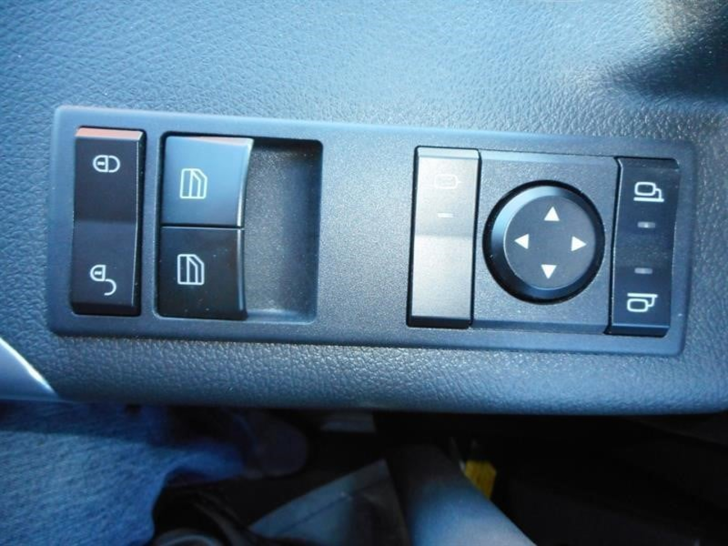 Truck interior control panel with window/ mirror adjustment controls and circular directional pad in a Western Star 47X cab.