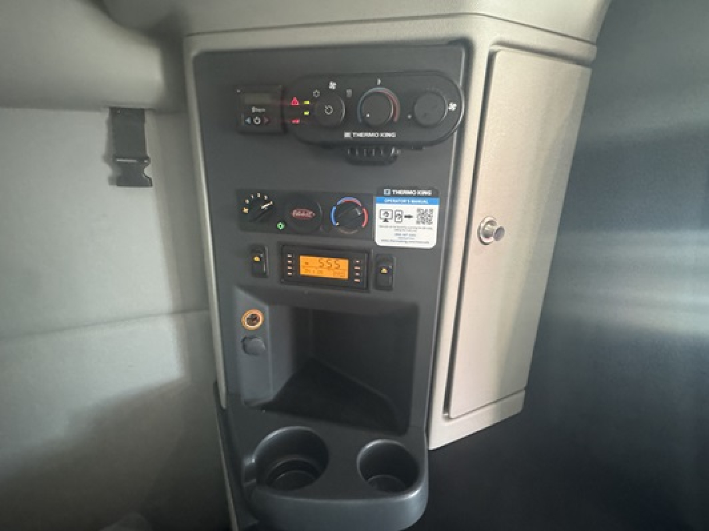 Peterbilt 579 dash/center console showing climate controls, radio, and storage with cup holders.