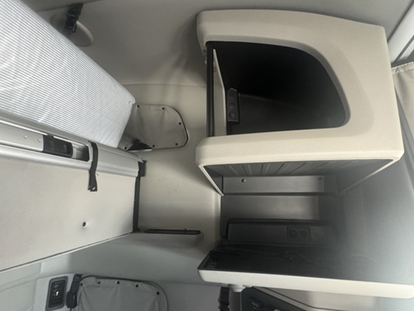 Peterbilt 579 sleeper cab interior showing storage compartments and a small open shelf with lid.