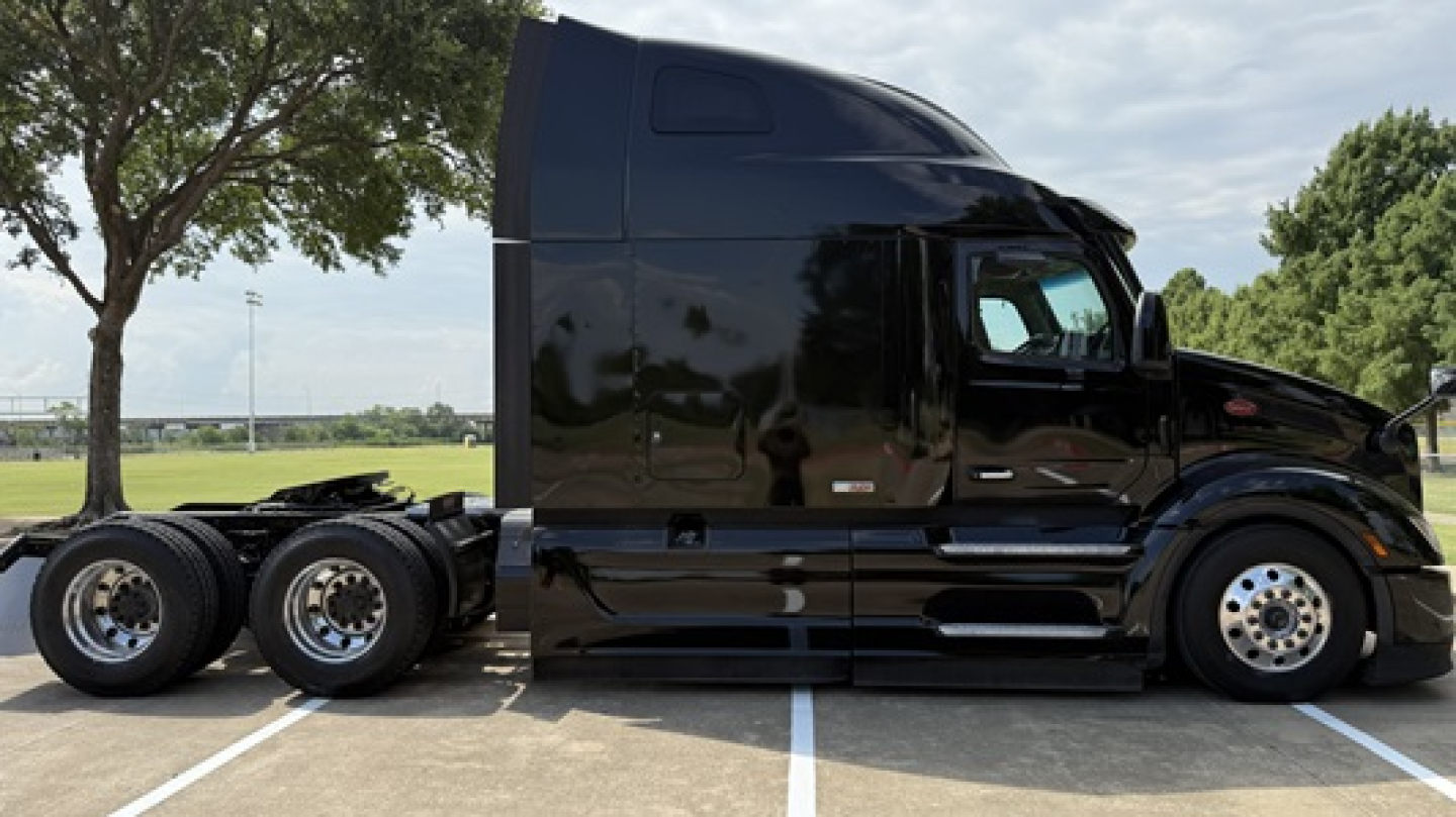 Peterbilt 579 tractor in black exterior, side view showing sleeper cab and dual rear axles with chrome wheels, VIN 1XPBD49XXPD854970 visible on listing, stock number 0630538.