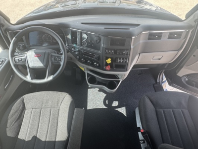 Peterbilt 579 interior dashboard and steering wheel view in a sleeper cab showing instrument cluster, center console, and seats.