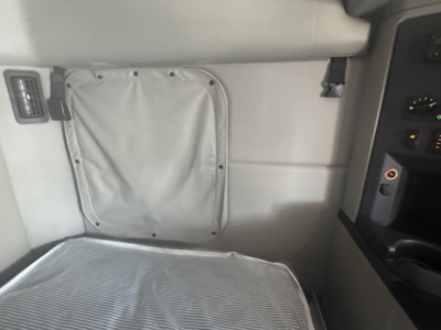 Peterbilt 579 sleeper cab interior with side panel, window vent cover, and dashboard visible