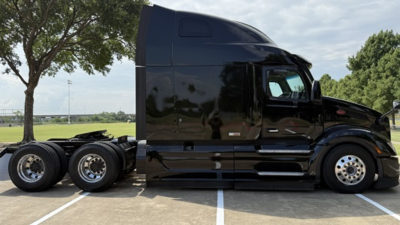 Peterbilt 579 tractor in black exterior, side view showing sleeper cab and dual rear axles with chrome wheels, VIN 1XPBD49XXPD854970 visible on listing, stock number 0630538.