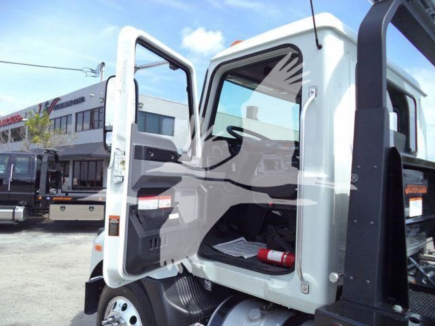 MD6 truck cab with door open showing interior dash and steering wheel, white exterior, Mack build details, rollback category.