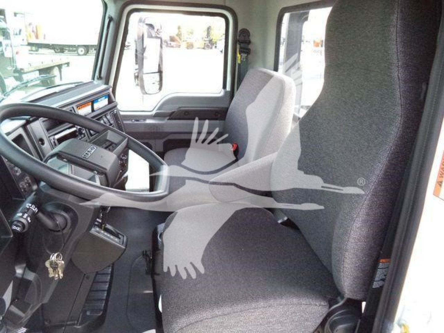 Truck cab interior showing steering wheel, dashboard, and driver seat of a 2027 Mack MD6 rollback truck.