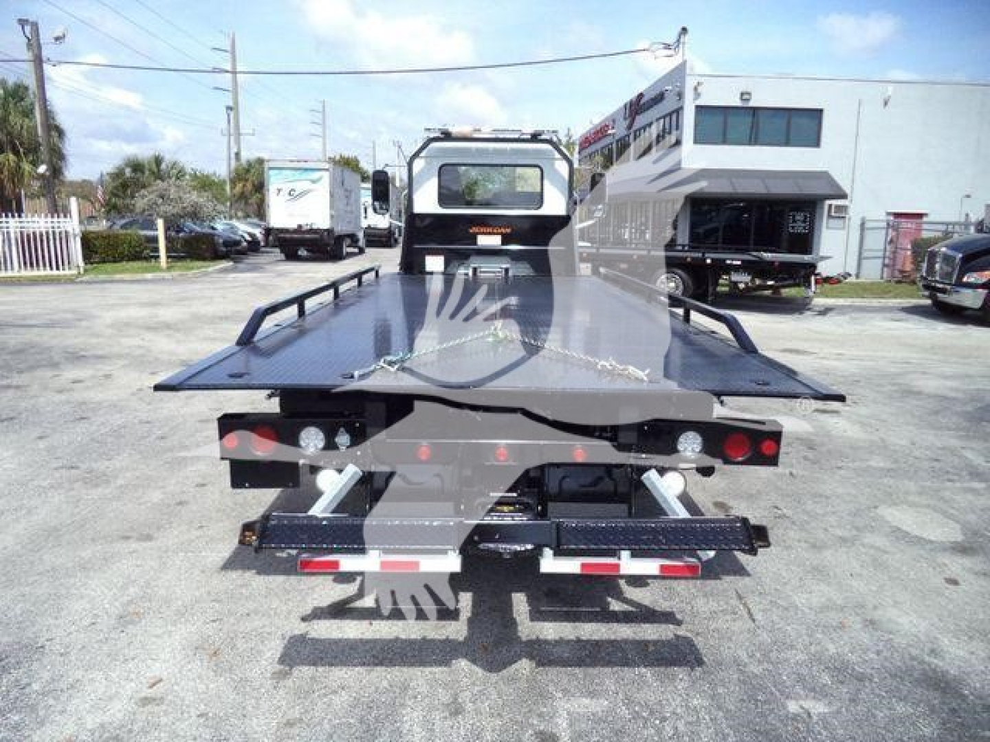 Mack MD6 rollback truck flatbed viewed from rear showing platform, taillights, and support structures.