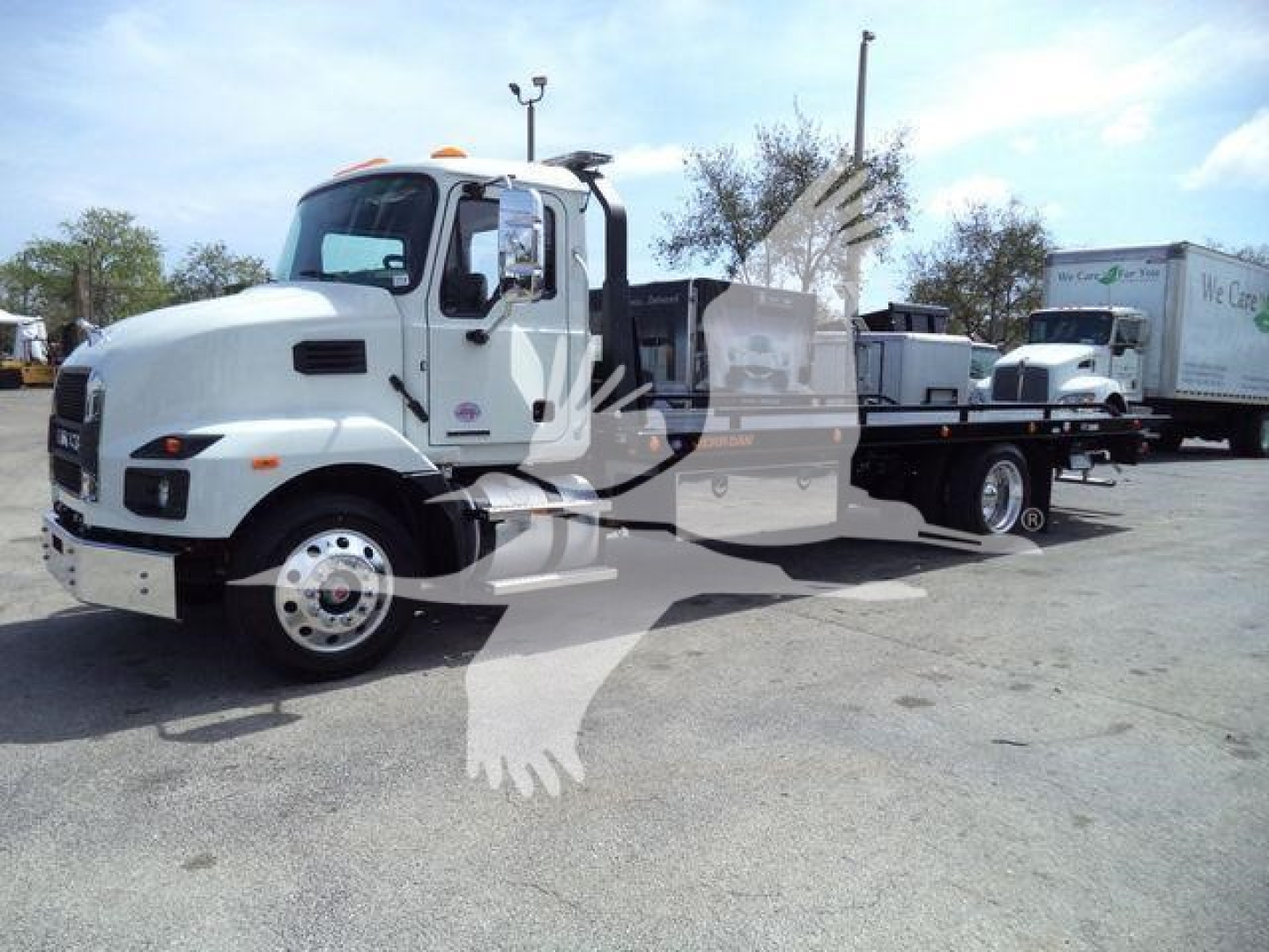 MD6 Mack rollback truck in white, side view showing flatbed with ramps and carrier, stock number J13303, new condition, Class 8 truck.