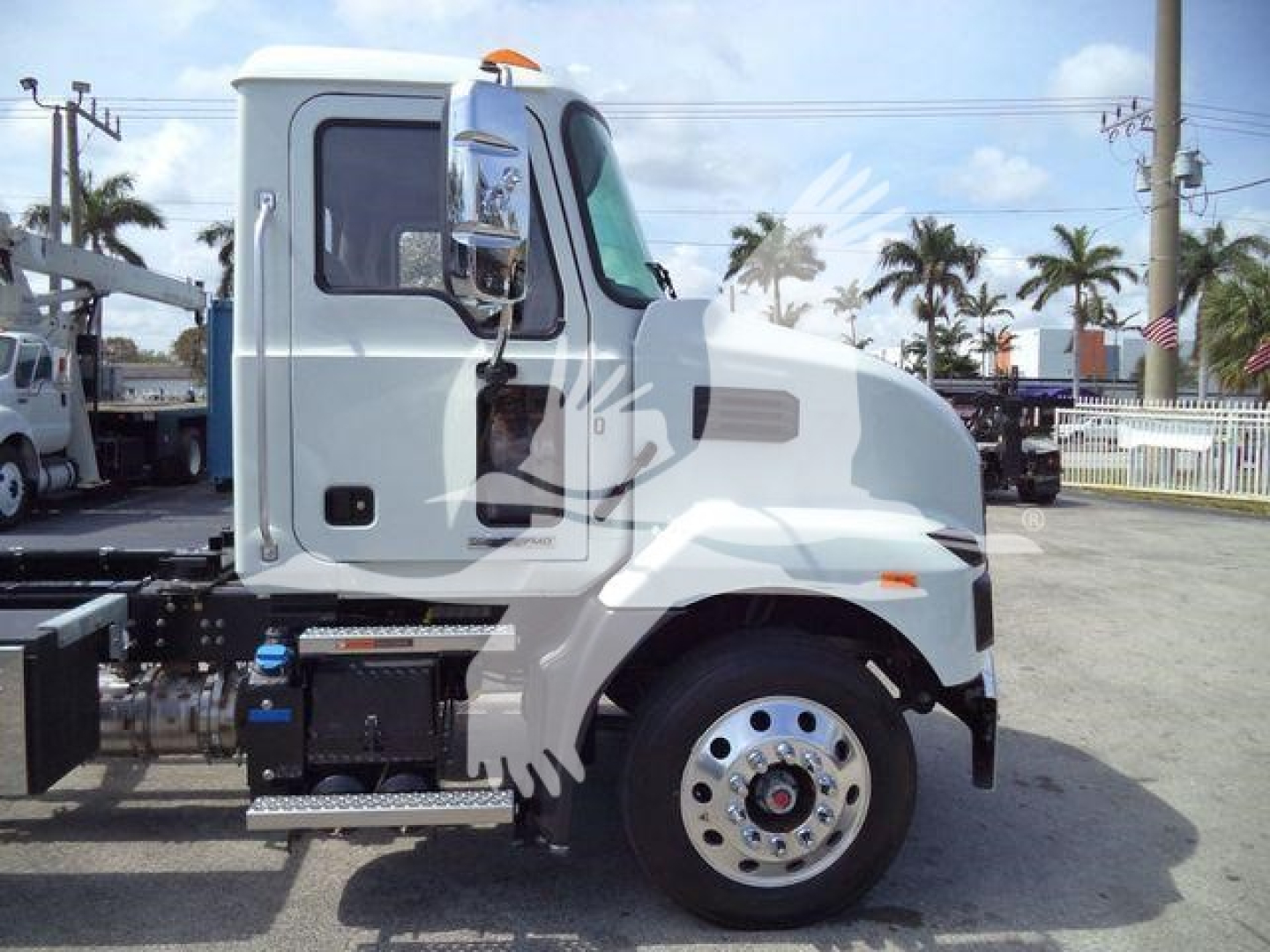 MD6 Mack chassis side view showing cab, front wheel with polished rim, fuel/access panels, and side step.