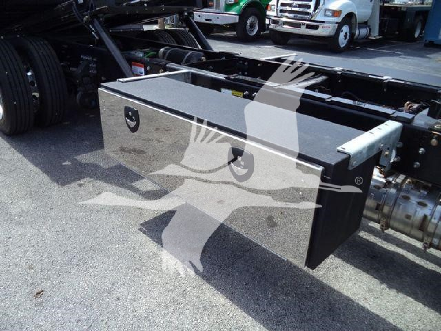Powerful truck service toolbox/drawer box mounted on a Mack MD6 rollback chassis showing a metal storage box with latches and mounting hardware.