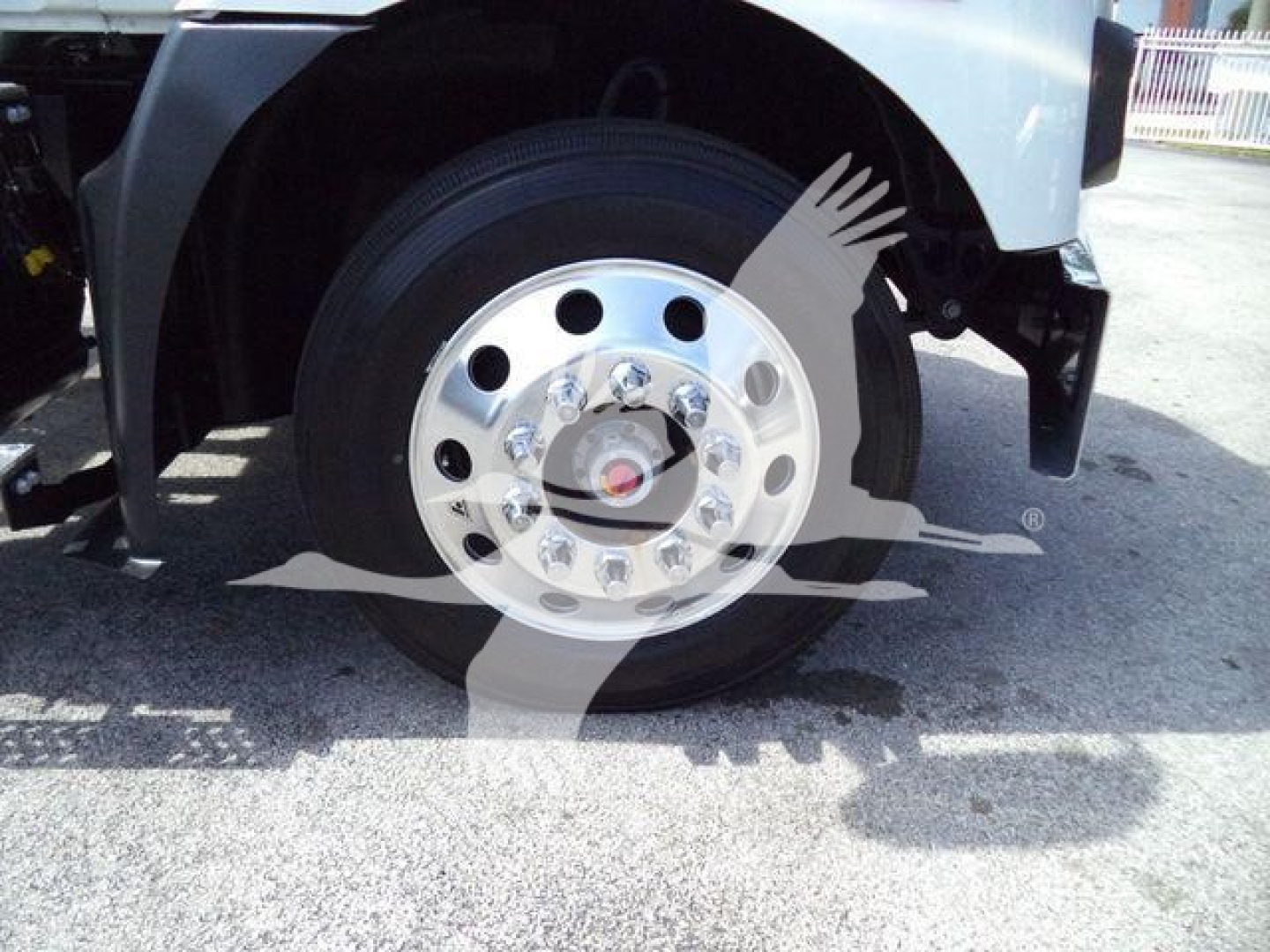 Truck front wheel and fender with shiny chrome hubcap and nearby tire; partial vehicle body visible.