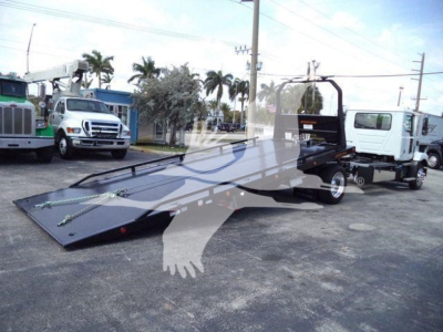 MD6 rollback truck showing flatbed loading ramp and side-loader in a truck lot.