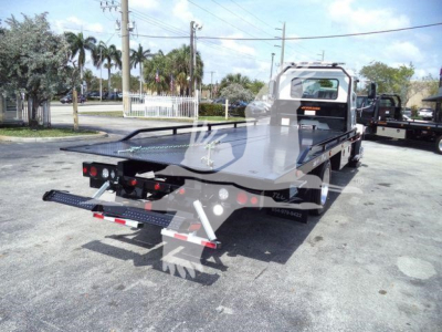 Flatbed tow truck rear view showing loading deck and ramps on a 2027 Mack MD6 rollback truck.