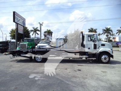 MD6 tow truck side view with flatbed, Mack badge visible, stock number J13303, rollback category, new truck.