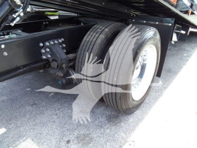 Truck undercarriage showing dual rear wheels and suspension components of a Mack MD6 rollback truck.