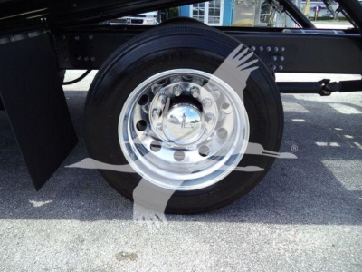 Rear wheel and heavy-duty chrome hub on Mack MD6 truck chassis showing polished steel wheel and tire, with frame and mud flap nearby.