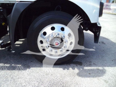 Truck front wheel and fender with shiny chrome hubcap and nearby tire; partial vehicle body visible.