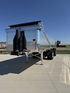 Hicks FH2827 spread axle dump trailer showing dual axles and silver aluminum body with black tongue and legs.