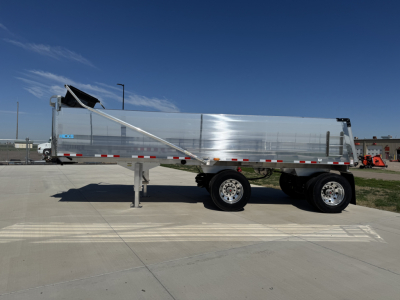 Hicks FL2827 spread axle dump trailer side view showing polished aluminum body and tandem axles.